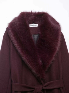 Detailed view of burgundy wool coat featuring a soft faux fur collar and inner brand label