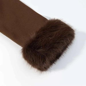 Détail de la manche d'un manteau en laine marron foncé avec bordure en fausse fourrure
