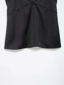 Detailed view of women's black satin camisole top featuring delicate lace trim on neckline