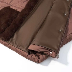 Detailed close-up of brown puffer jacket lining with faux fur and metallic snap buttons
