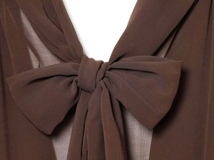 Close-up of the large brown chiffon bow detail on a long-sleeved mini dress