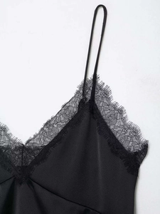 Close-up of black satin camisole top with intricate eyelash lace trim at neckline