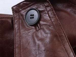 Detail of dark brown leather texture with stitching and a black four-hole button