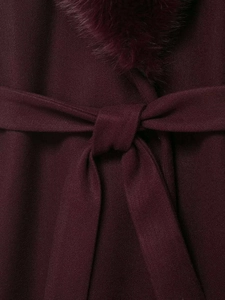 Detail of burgundy wool coat showing waist belt tie and luxurious faux fur collar texture