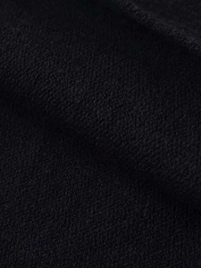 Nahaufnahme des schwarzen Strickstoffs mit körniger Textur und hochwertiger Webstruktur