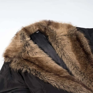 Detail shot of a warm brown faux fur collar on a black winter jacket with windproof fabric