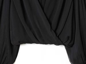 Detail of black V-neck pleated chiffon shirt with vertical striped texture and crossover design