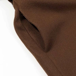 Détail de la poche latérale d'une veste en laine marron foncé avec tissage texturé
