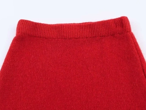 Close-up of the red knit skirt featuring a high elastic waist and ribbed texture