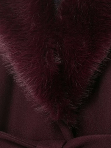 Detailed close-up of dark wine red wool coat with luxurious faux fur collar and fine texture