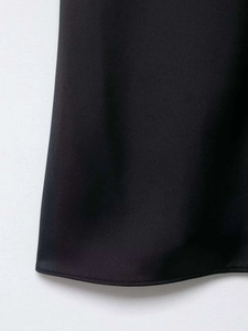 Detail of sleek black satin hem with professional stitching on lace camisole top