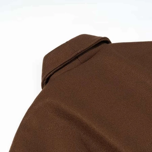 Vue détaillée du col en laine marron foncé et des coutures d'épaule d'un manteau