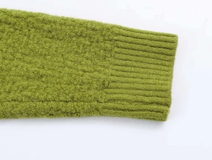 Close-up of ribbed cuffs on grass green chunky knit sweater with high-quality texture