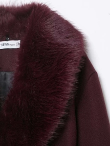 Detail of burgundy wool coat showing fluffy faux fur collar and size label closeup