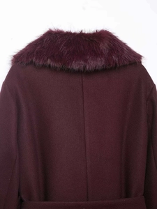 Detail view of burgundy wool coat showing fluffy faux fur collar and textured back seam