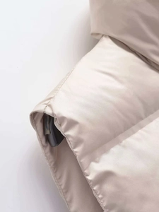 Détail du tissu de gilet matelassé beige clair et de sa texture soyeuse