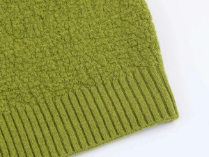 Detail of green knit cardigan showing the thick teddy fleece texture and ribbed hem