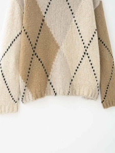 Gros plan sur un pull en maille rétro à motifs de losanges et blocs de couleurs beige