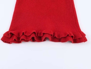 Detailed close-up of vibrant red knit fabric featuring double-layered ruffle hem