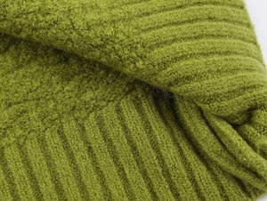 Detailed close-up of grass green ribbed knit fabric showing soft wool texture