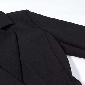 Detail of classic notched lapel and high-quality woven fabric on a black blazer dress