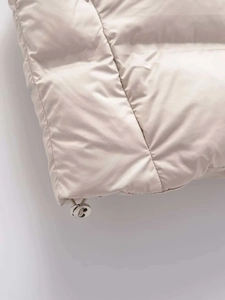 Détail de l'ourlet de la veste matelassée beige avec cordon de serrage argenté