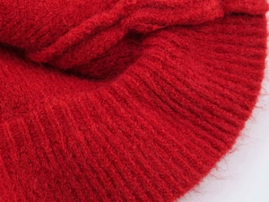 Detailed close-up of high-quality red ribbed knit fabric with soft texture and vibrant color