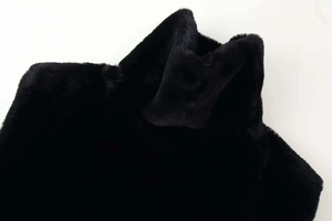 Close-up detail of high collar on a plush black faux fur vest with soft texture