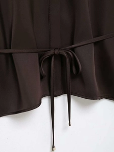 Vue détaillée de la chemise en satin marron foncé avec ceinture nouée et couture précise