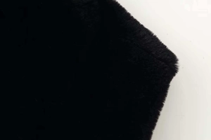 Close-up of black faux fur material showing soft texture and high-density long plush fiber