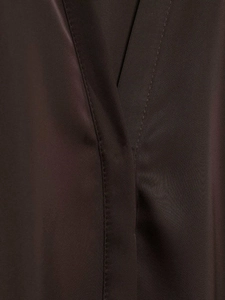 Vue macro détaillée du tissu satiné marron foncé et des coutures soignées sur la chemise