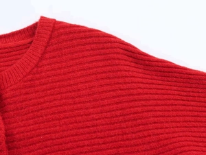 Detailed view of red ribbed knit top collar and soft vertical textured fabric quality