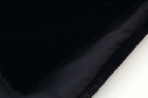 Detail shot of black faux fur exterior fabric with smooth lining for winter vest