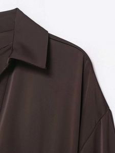 Gros plan du col d'une chemise en satin marron chocolat avec texture sergée de qualité