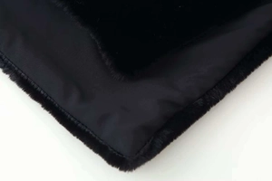 Close-up of black sleeveless vest showing plush faux fur texture and smooth inner lining