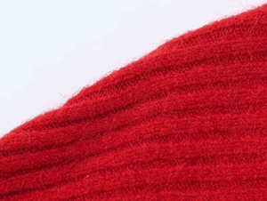 Macro detail of vibrant red knit fabric showing premium texture and ribbed pattern