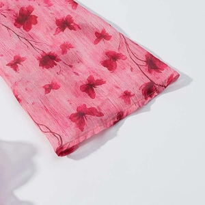 Detail of pink floral dress cuff with romantic butterfly print and crinkle texture