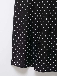 Vue macro détaillée du tissu à pois noir et blanc sur une robe d'été à bretelles