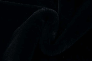 Detailed macro view of premium black faux fur fabric with soft texture and subtle glossy finish