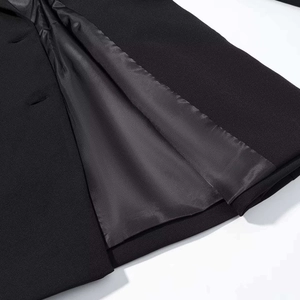 Detail view of high-quality stitching, buttonhole, and silky satin lining of black blazer