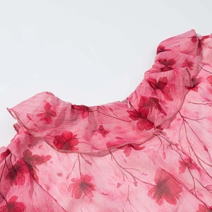 Close-up of pink floral print dress showing v-neck ruffle and soft chiffon texture