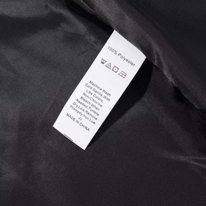 Detailed view of white fabric care label showing 100% polyester on black dress lining