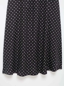 Gros plan détaillé d'une robe d'été à pois noirs et blancs avec un tissu léger fluide
