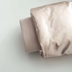 Detail of champagne gold metallic fabric sleeve with elastic ribbed knit cuffs