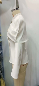 Detailed view of white short cape jacket with elegant stand collar and layered sleeves