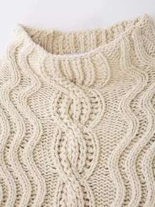 Close-up of cream cable-knit sweater collar showcasing thick textured knit patterns