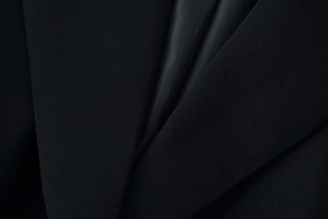 Detail of premium black blazer fabric texture with smooth satin lining and sharp stitching