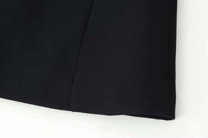 Close-up of premium black woven fabric texture and seam craftsmanship on two-piece set