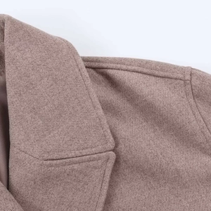 Close-up of notched lapel and thick wool fabric texture on brown cropped jacket