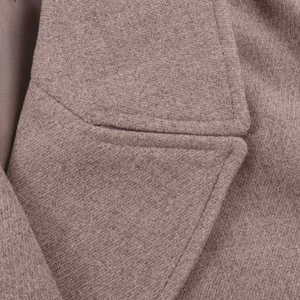 Detailed macro view of wool blend fabric texture and stitching on a double-breasted coat